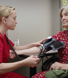 a woman with a stethoscope listening to a patient