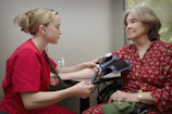 a woman with a stethoscope listening to a patient