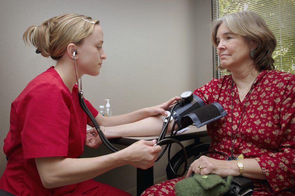 a woman with a stethoscope listening to a patient