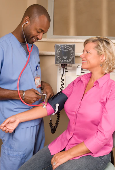 a doctor checking a patient's blood with a stethoscope