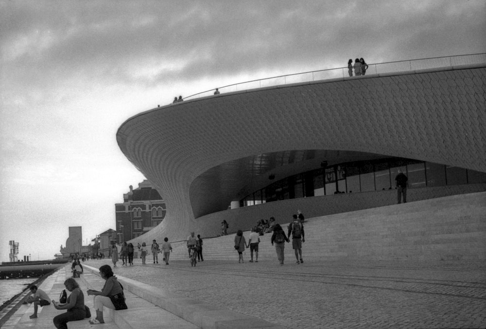 a black and white photo of people walking on a sidewalk