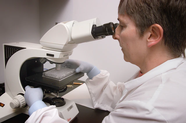 Researcher working at a microscope
