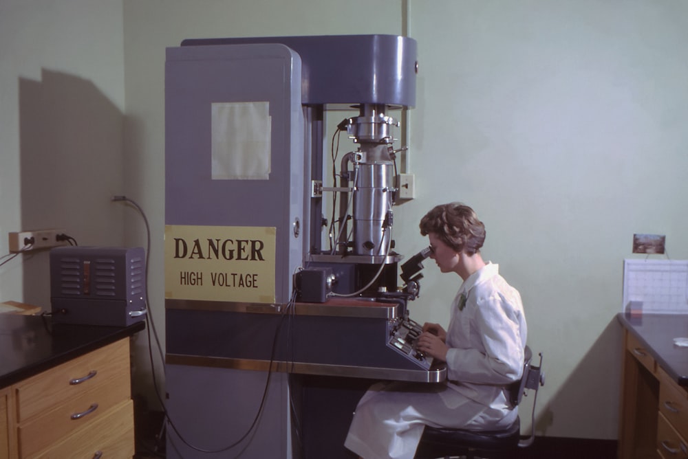 a woman in a wheelchair working on a machine