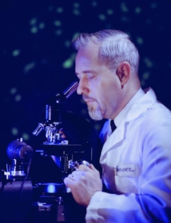a man looking through a microscope at something