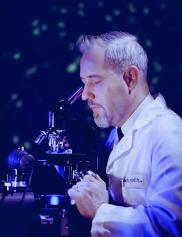 a man looking through a microscope at something