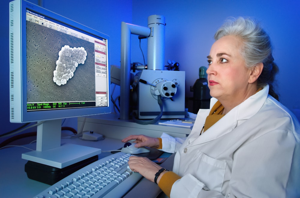 a woman sitting in front of a computer monitor