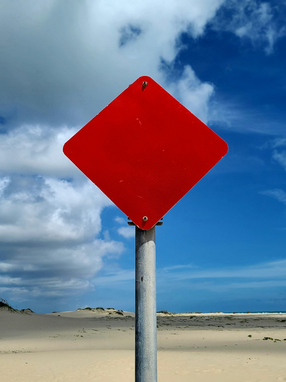 a red street sign sitting on top of a metal pole