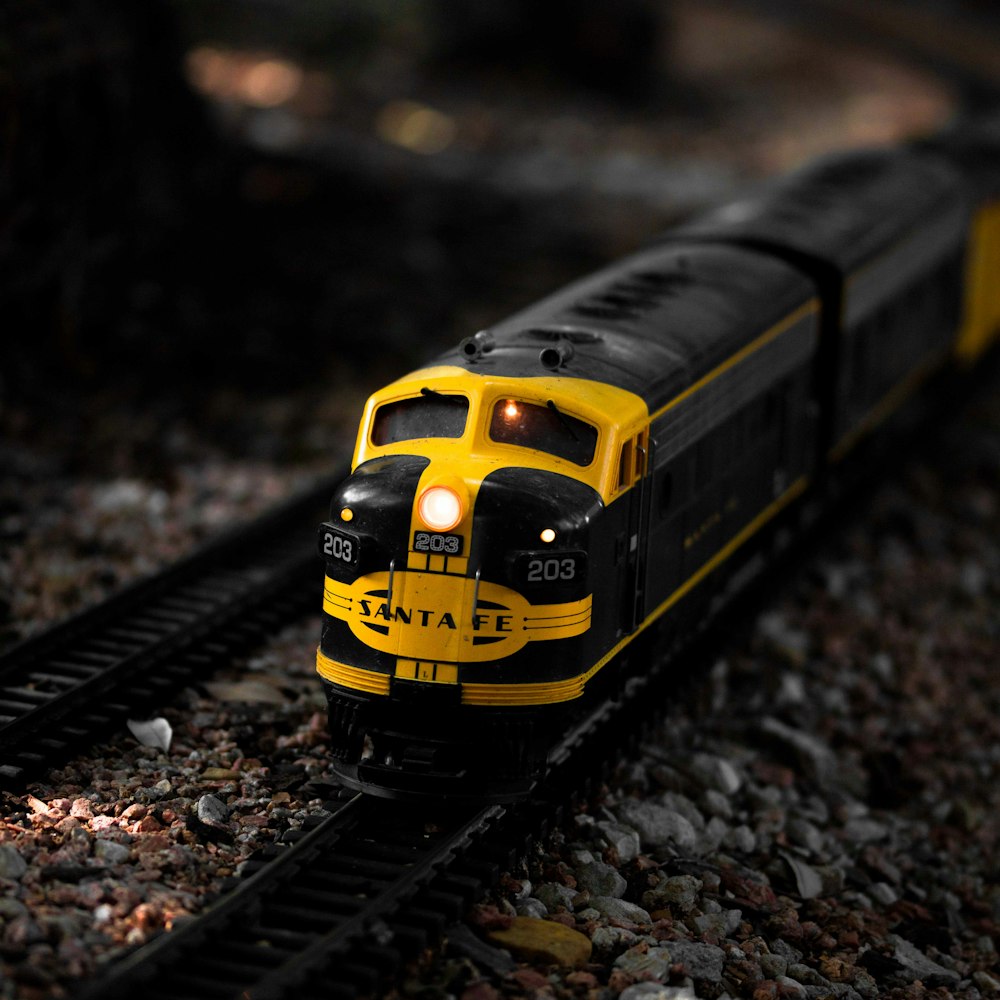 a yellow and black train traveling down train tracks