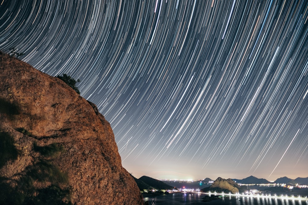 a star trail is seen over a body of water