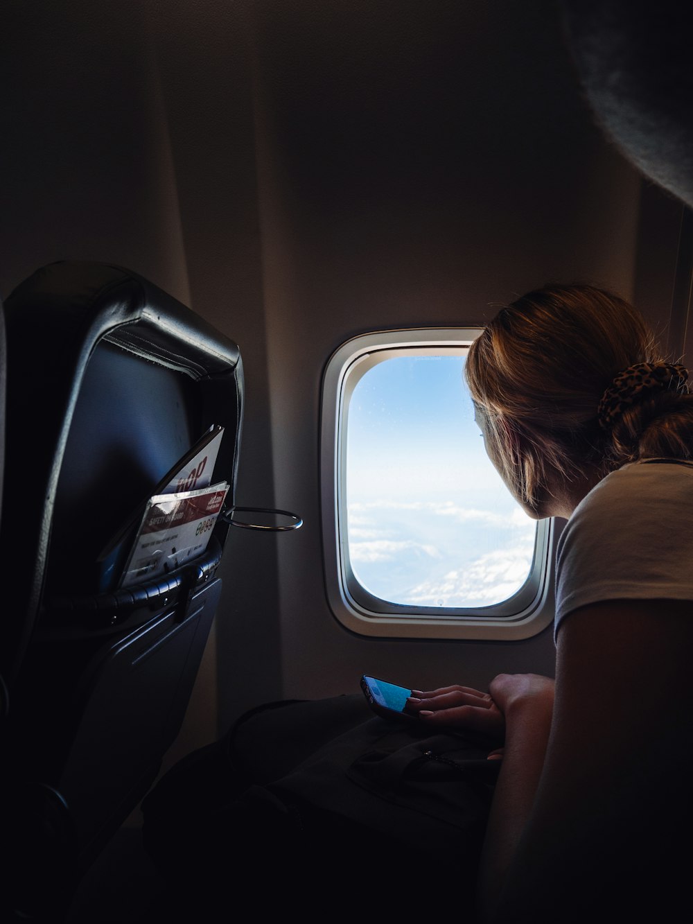 飛行機の窓の外を眺める女性