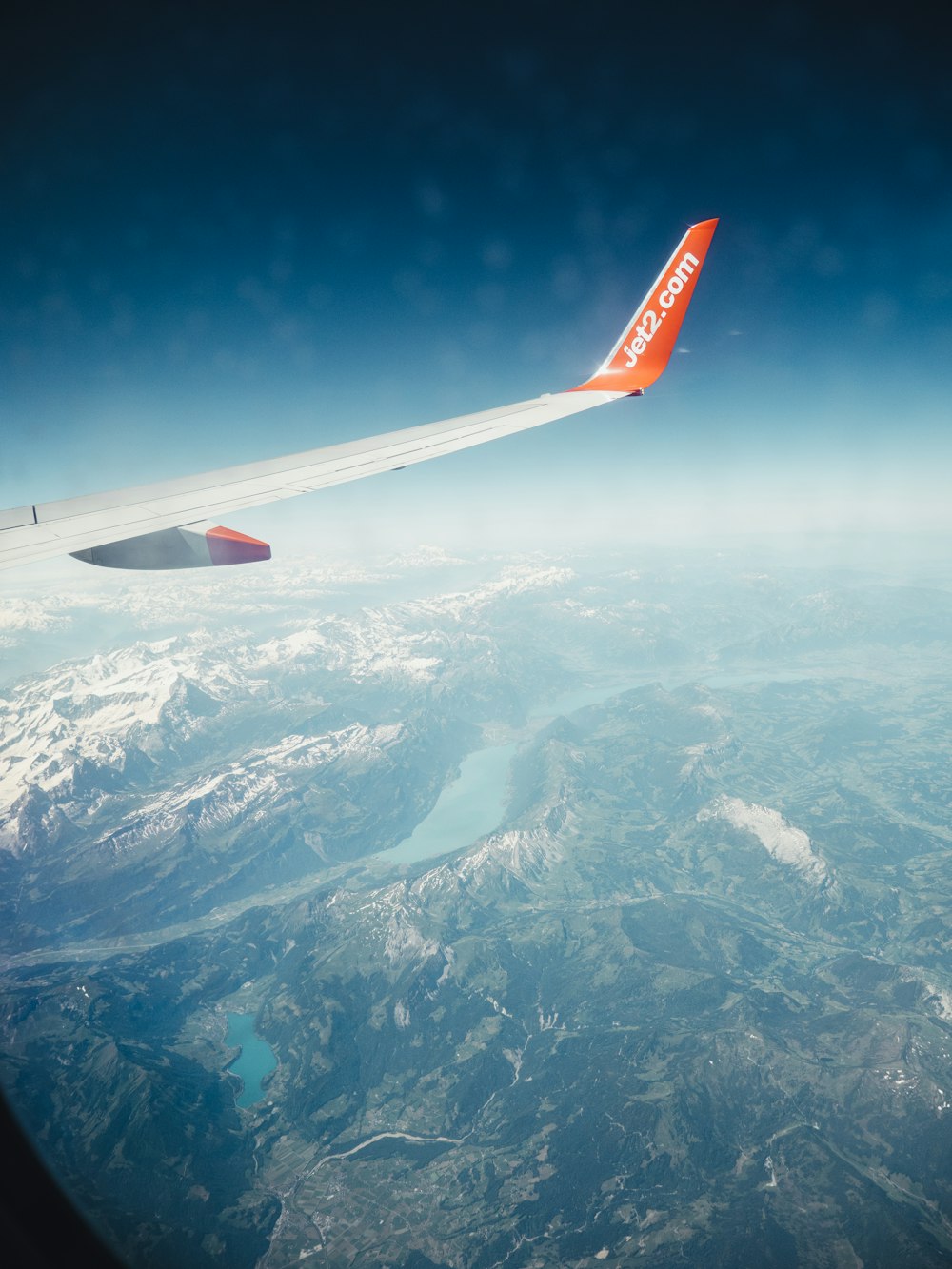 the wing of an airplane flying over a mountain range