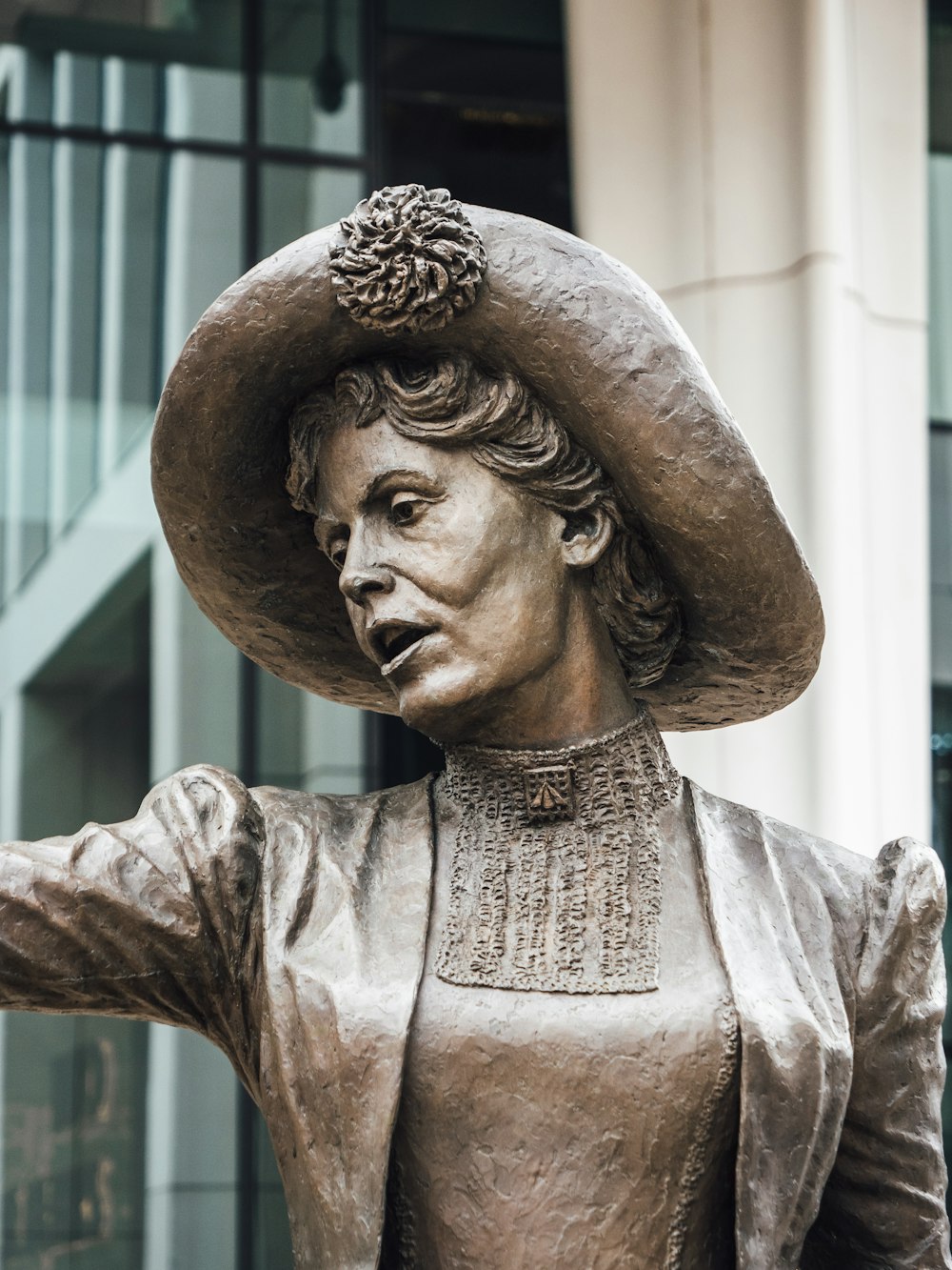 uma estátua de uma mulher com um chapéu na cabeça