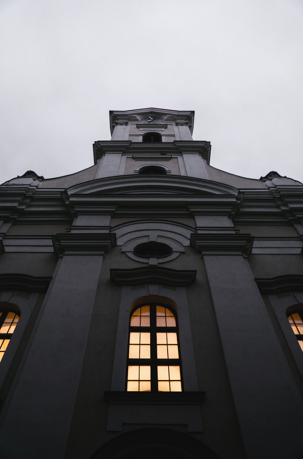 a tall building with two windows and a clock on the top of it