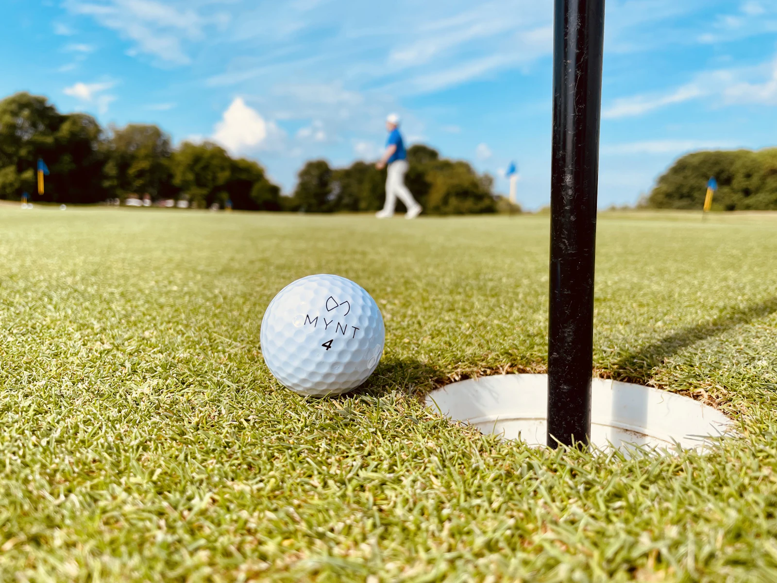 Golf ball resting near the hole on a putting green