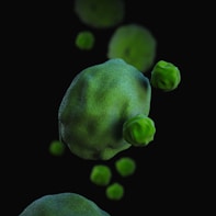 a green substance floating in the air on a black background