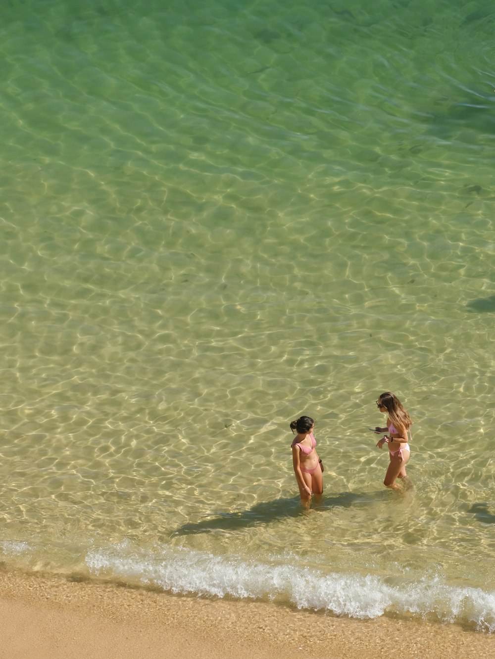 two little girls standing in the water at the beach
