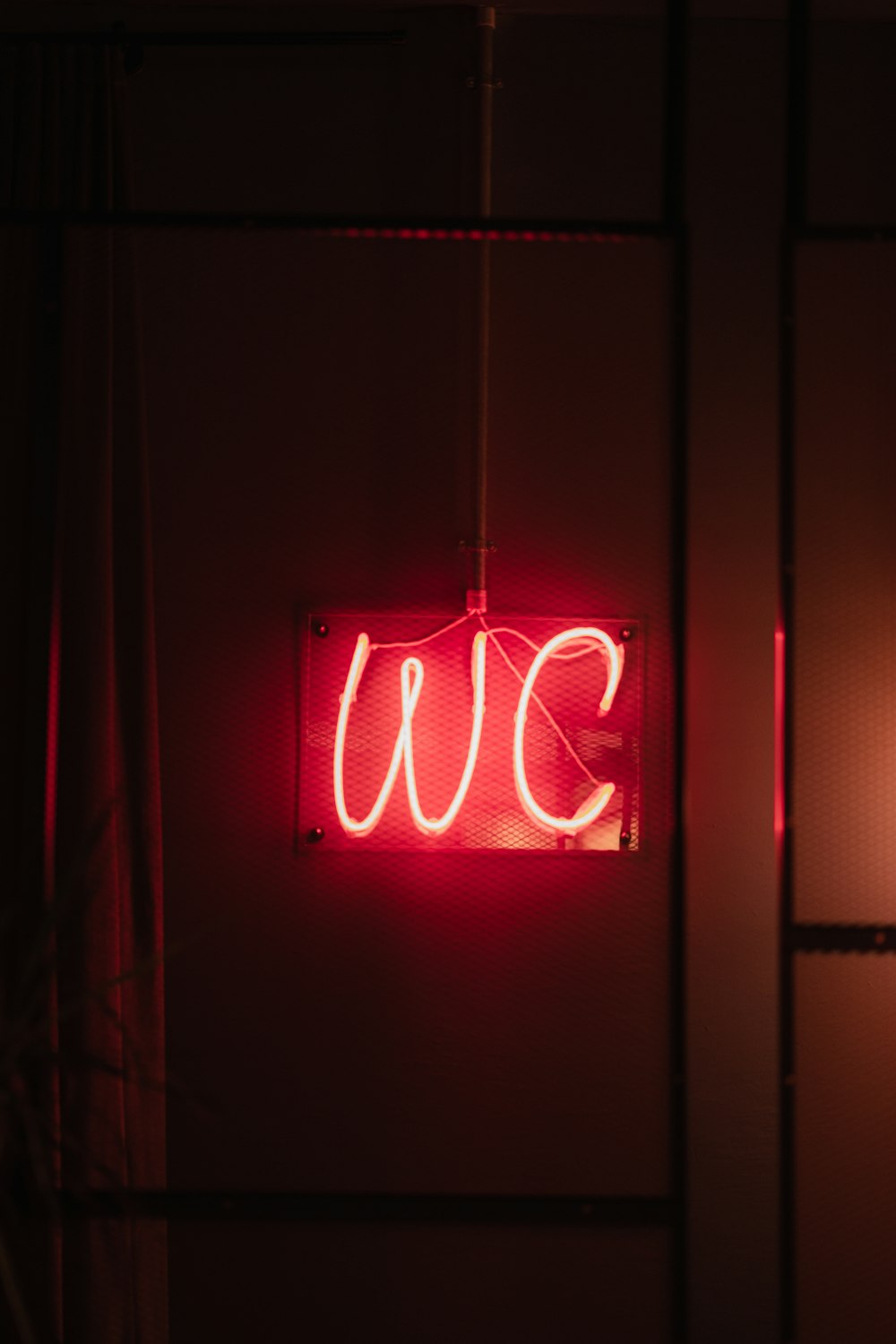 a red neon sign hanging from the side of a wall