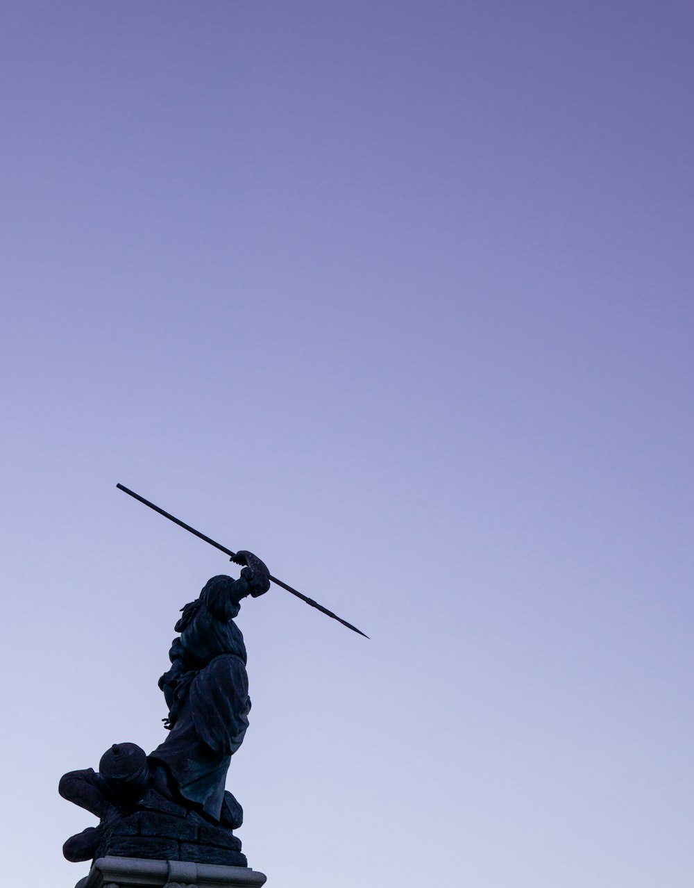 a statue of a person holding a sword on top of a building