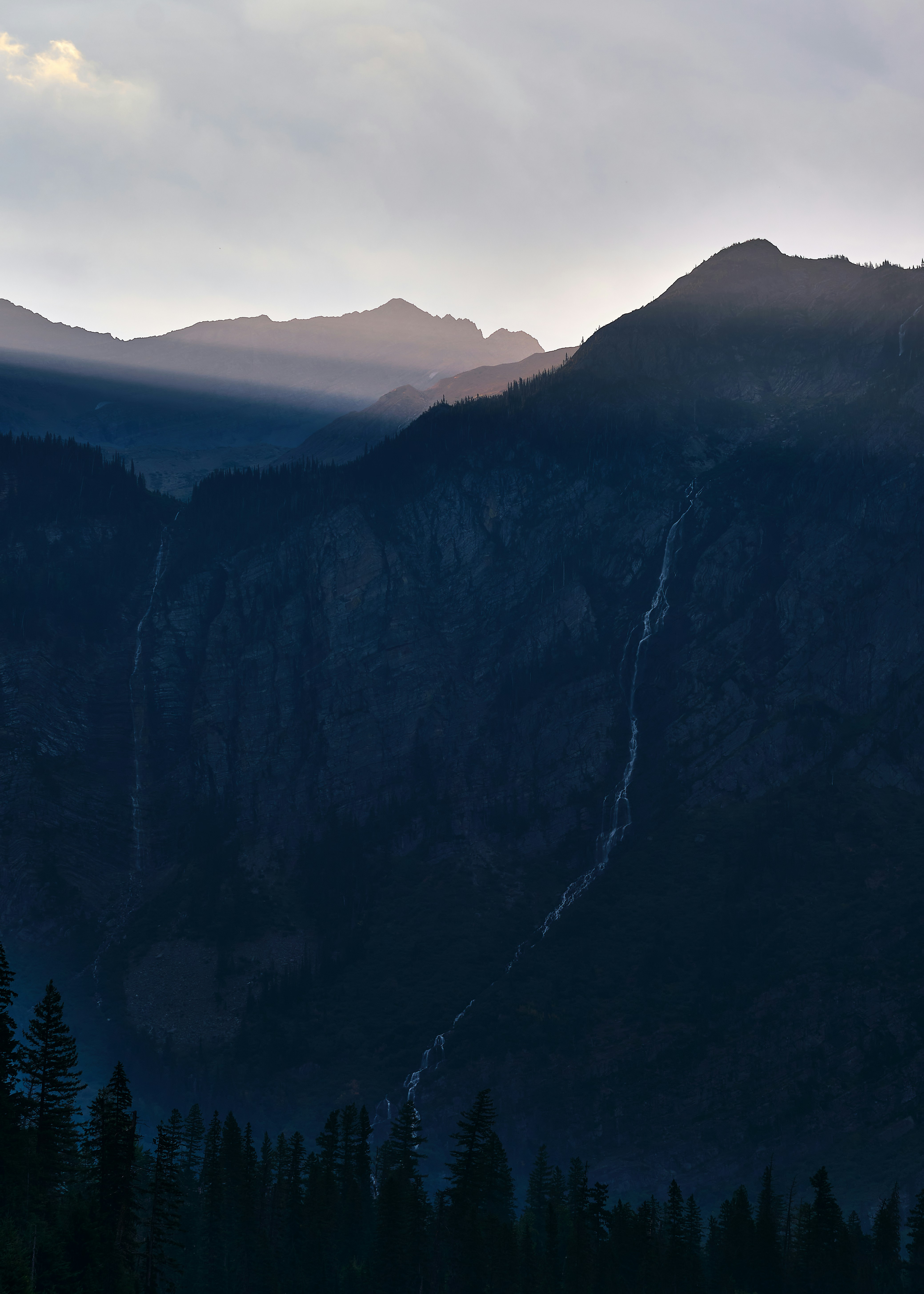 a mountain range with trees and mountains in the background