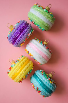four colorful cupcakes with sprinkles on them