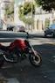 a red motorcycle parked on the side of the road