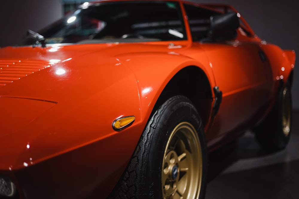 a close up of a red sports car on display