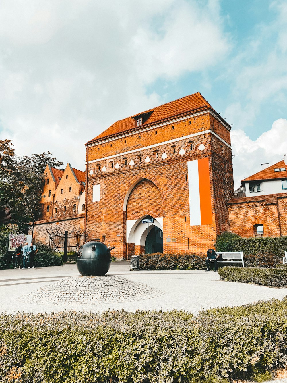 a brick building with a large black ball in front of it