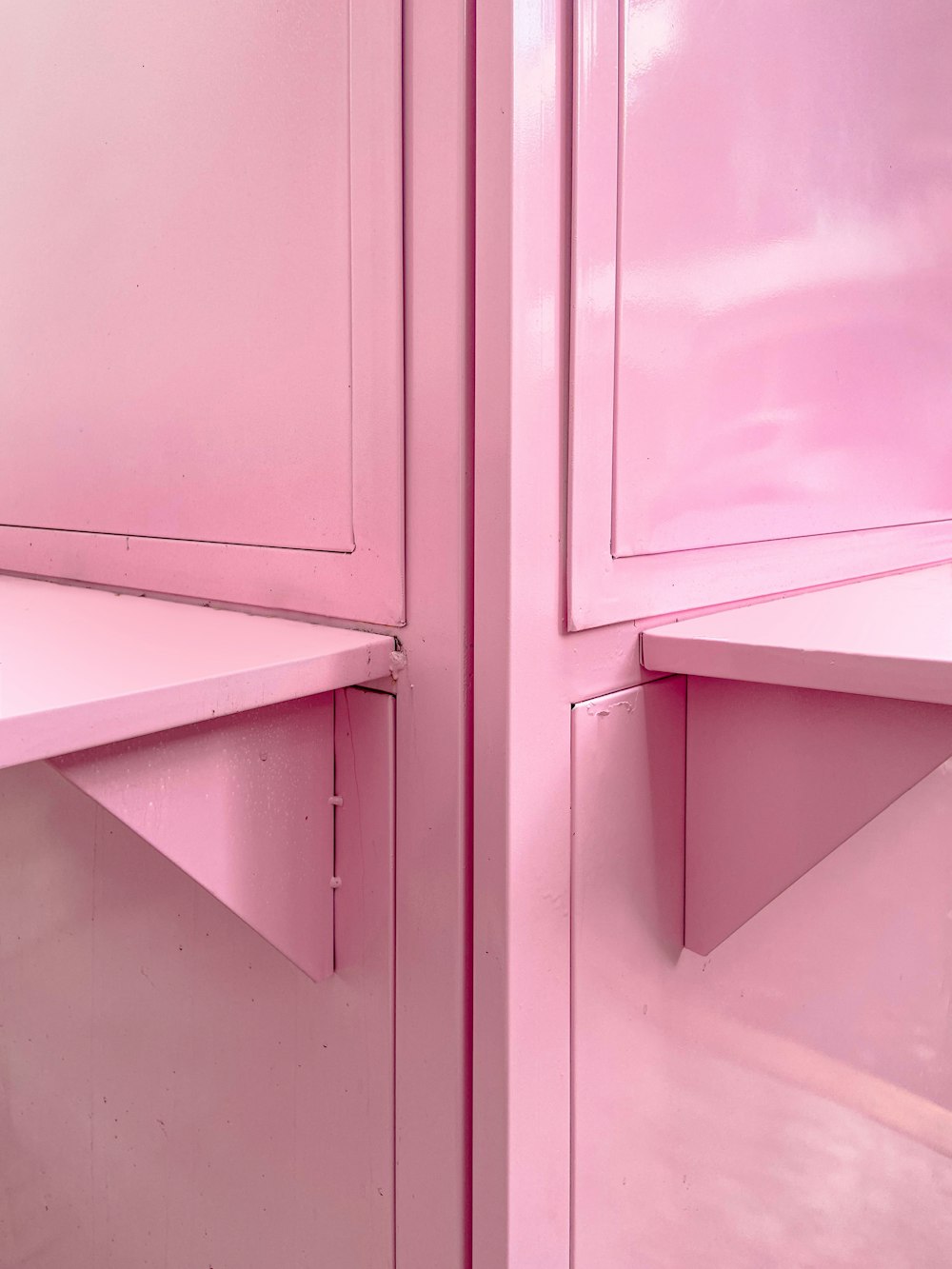 um quarto rosa com uma prateleira e armários