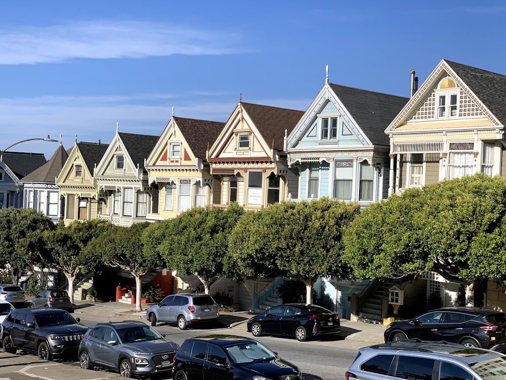 a row of houses with cars parked in front of them