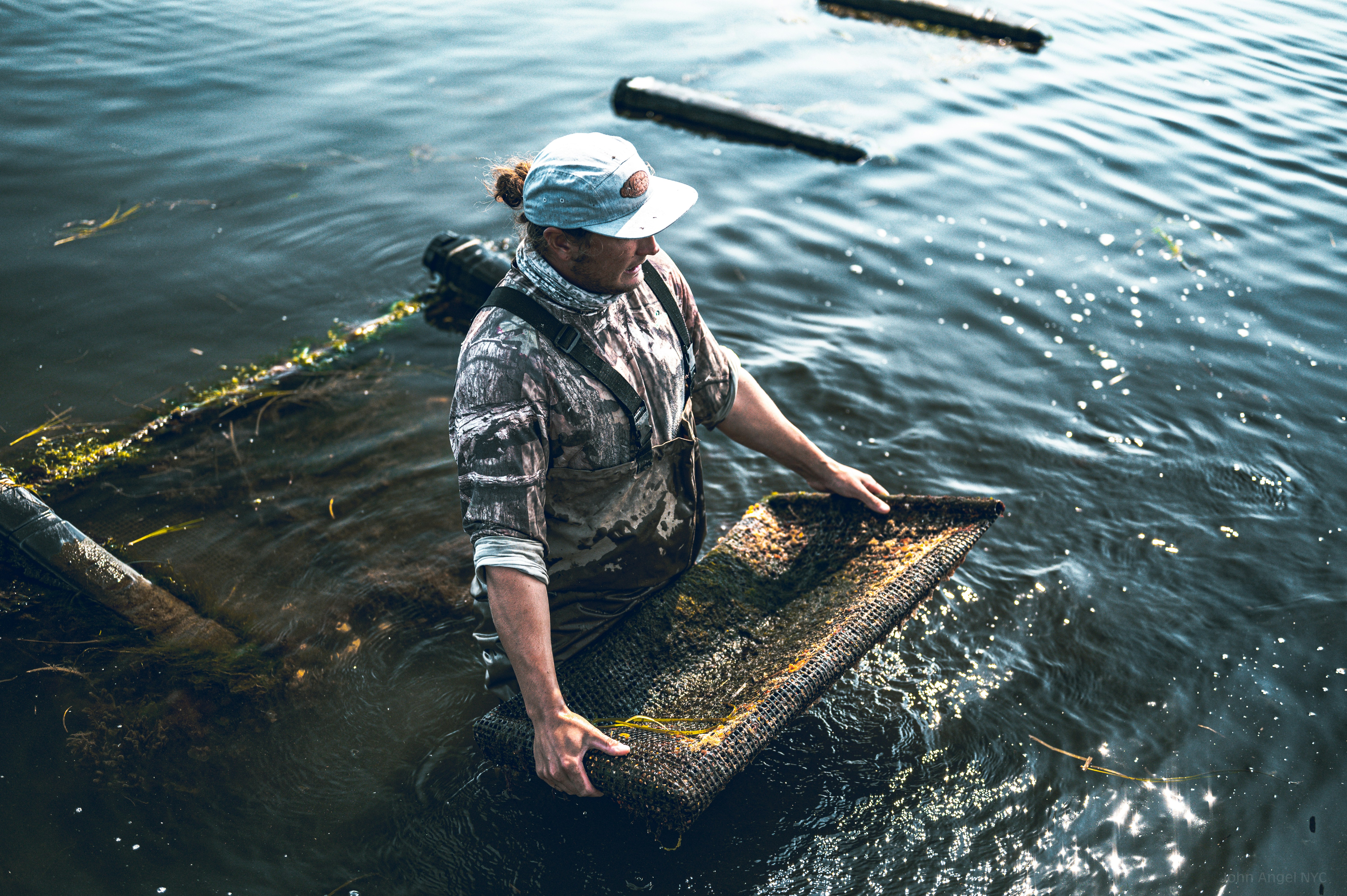 a man standing in a body of water, Matunuck Oyster Farm in Rhode Island.