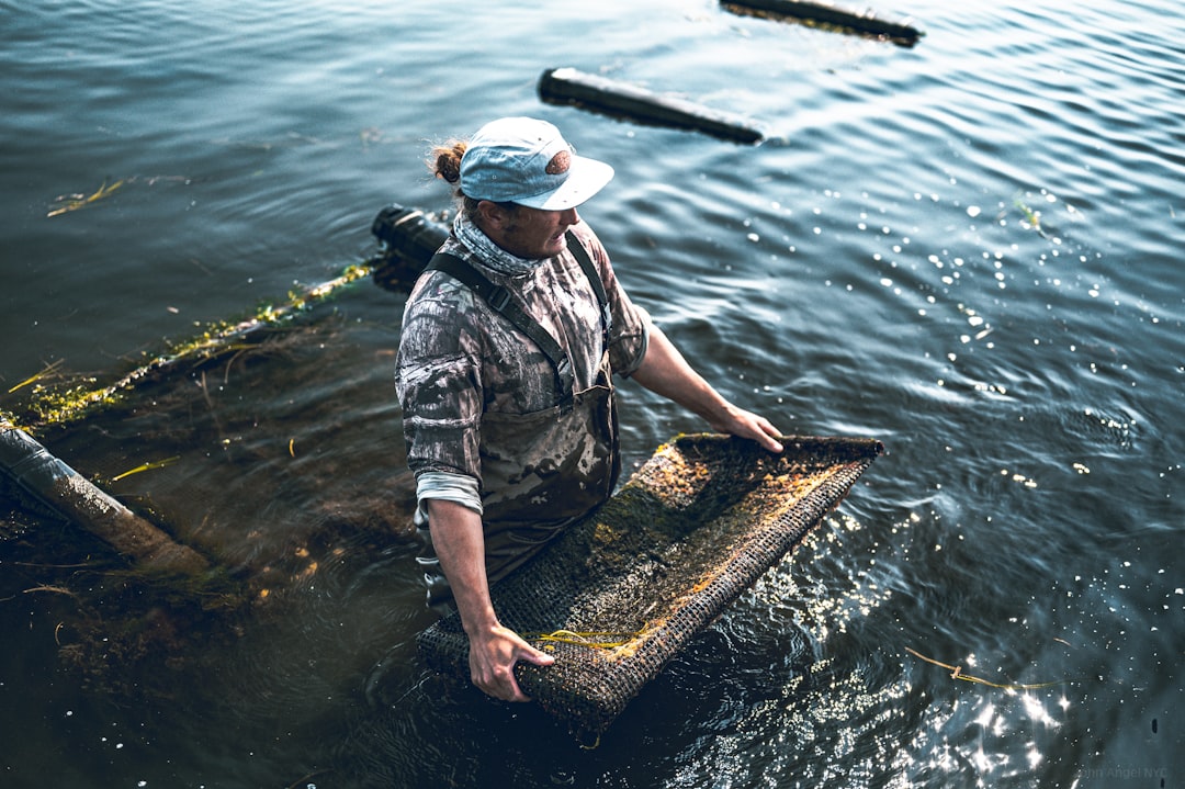 a man standing in a body of water, Matunuck Oyster Farm in Rhode Island.