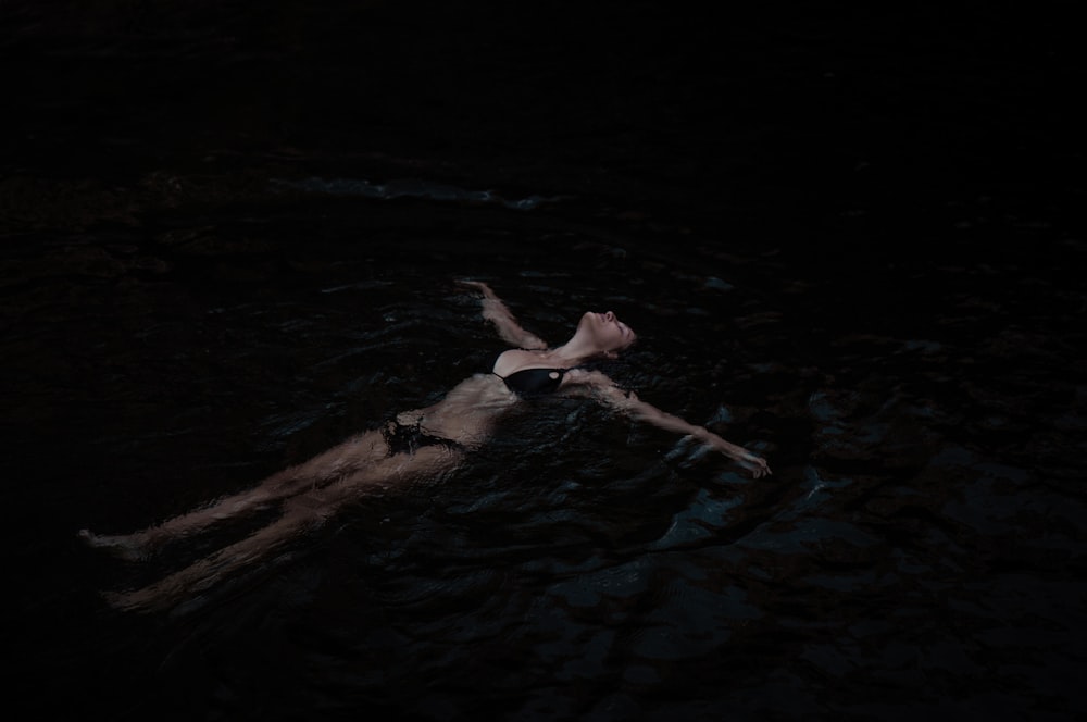 a woman floating in the water at night