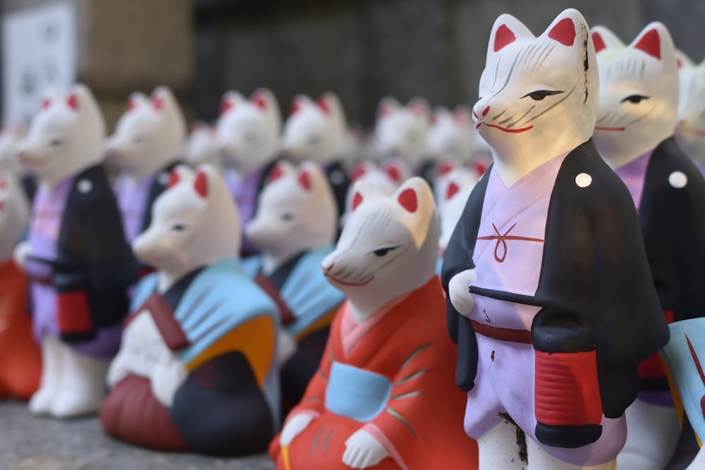 a row of ceramic cats sitting next to each other