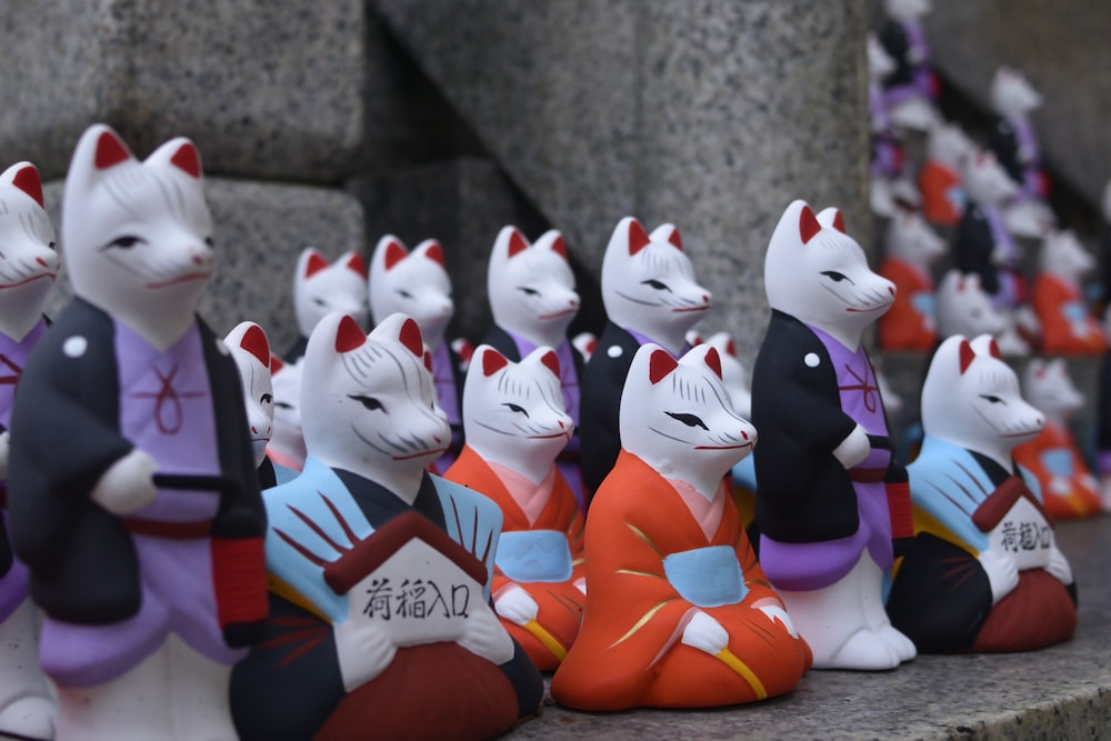 a group of small figurines of cats sitting on a ledge