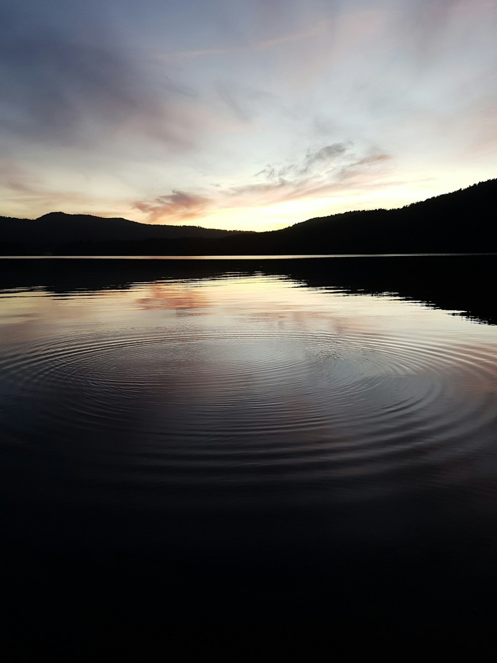 a large body of water with a sunset in the background