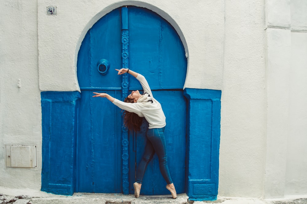 a woman standing in front of a blue door