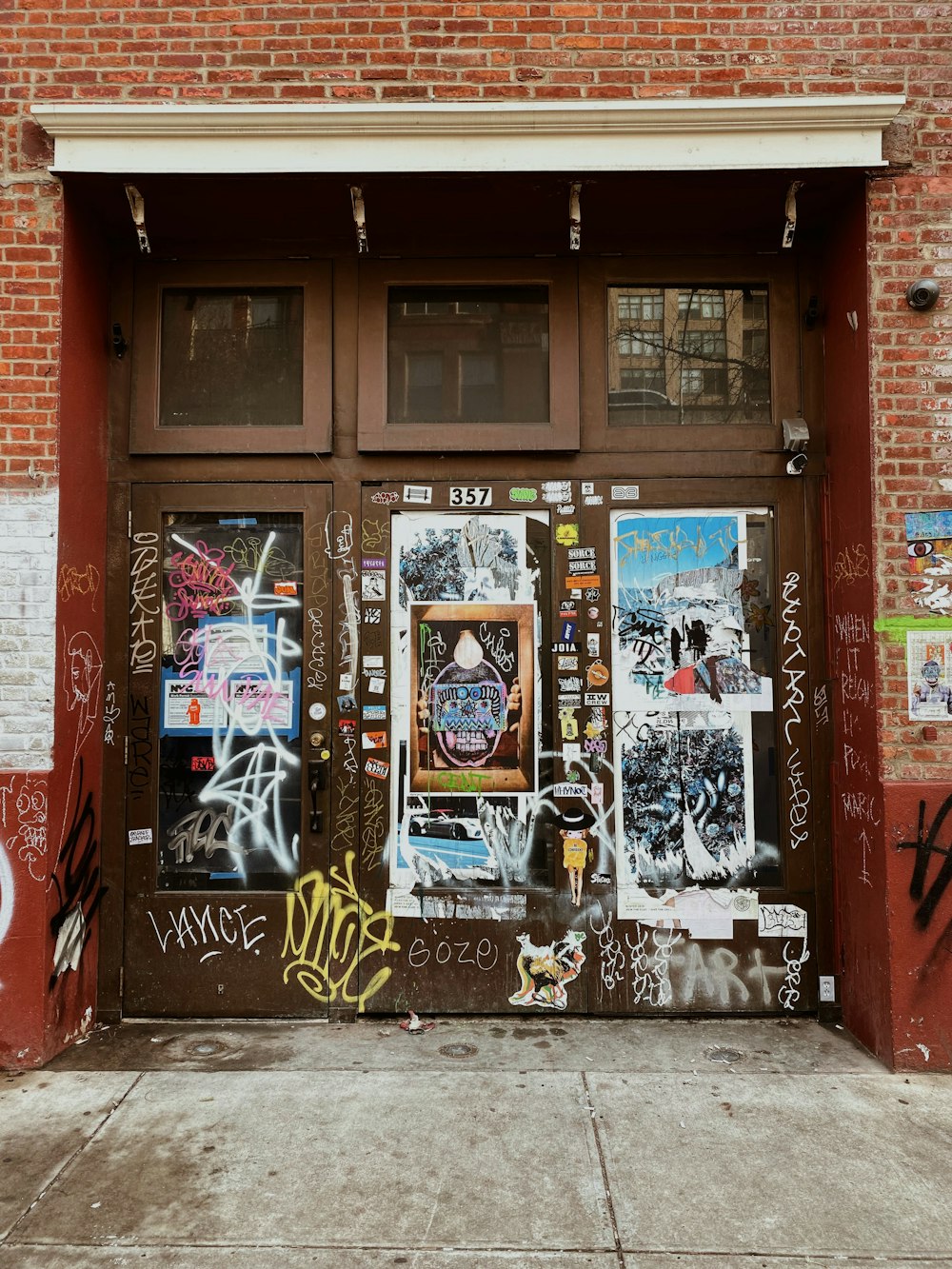 a door with graffiti on it in front of a brick building