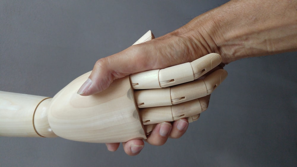 a close up of a person holding a wooden object