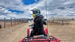 a person riding a red four wheeler on a dirt road