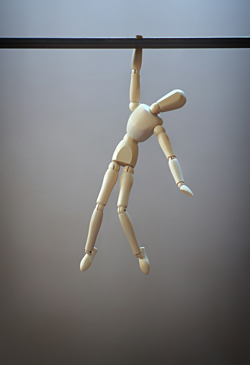 une poupée en bois suspendue à une corde à linge