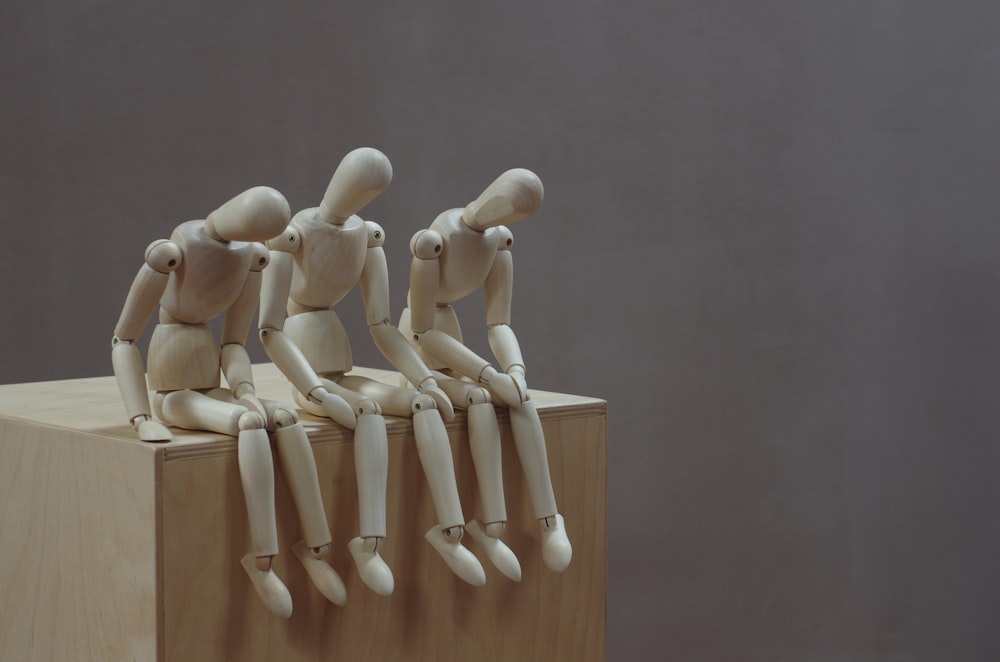 a group of wooden mannequins sitting on top of a wooden block