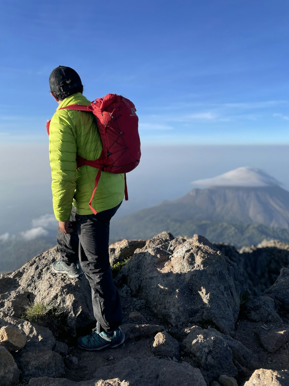 Un homme avec un sac à dos au sommet d’une montagne