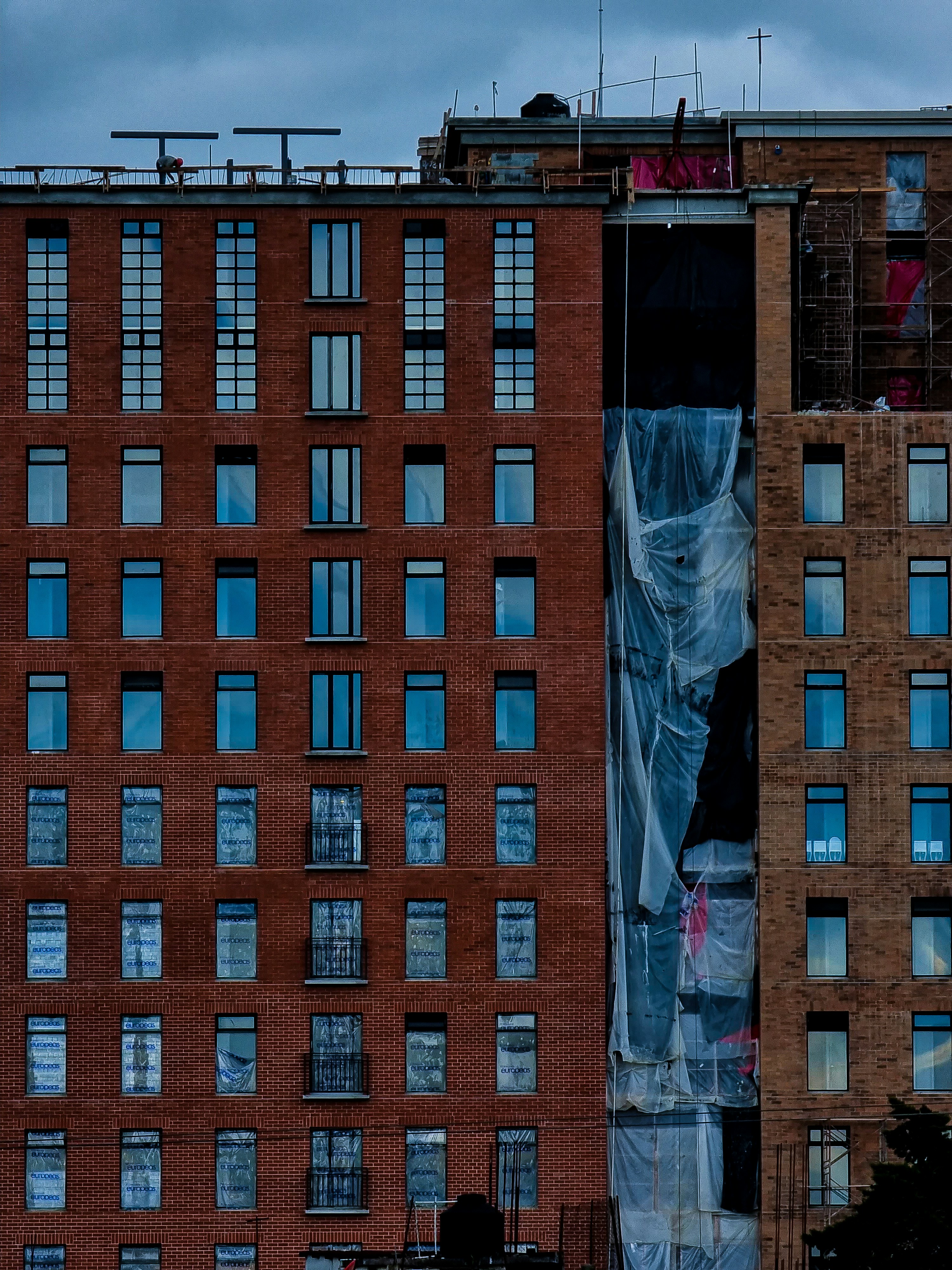 A tall brick building with lots of windows photo – Free Building Image ...
