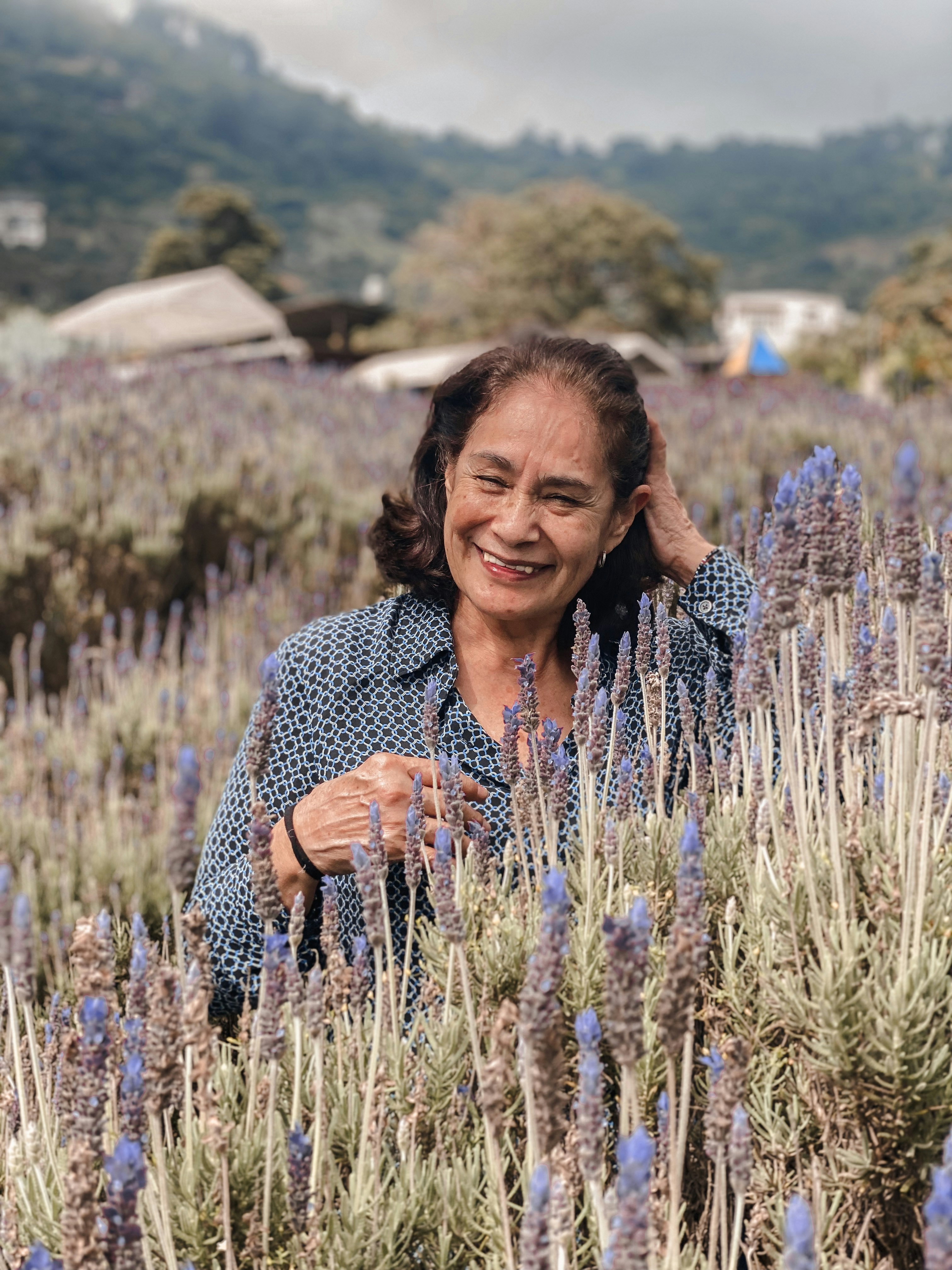 Woman with dark hair smiling outdoors in mountain setting