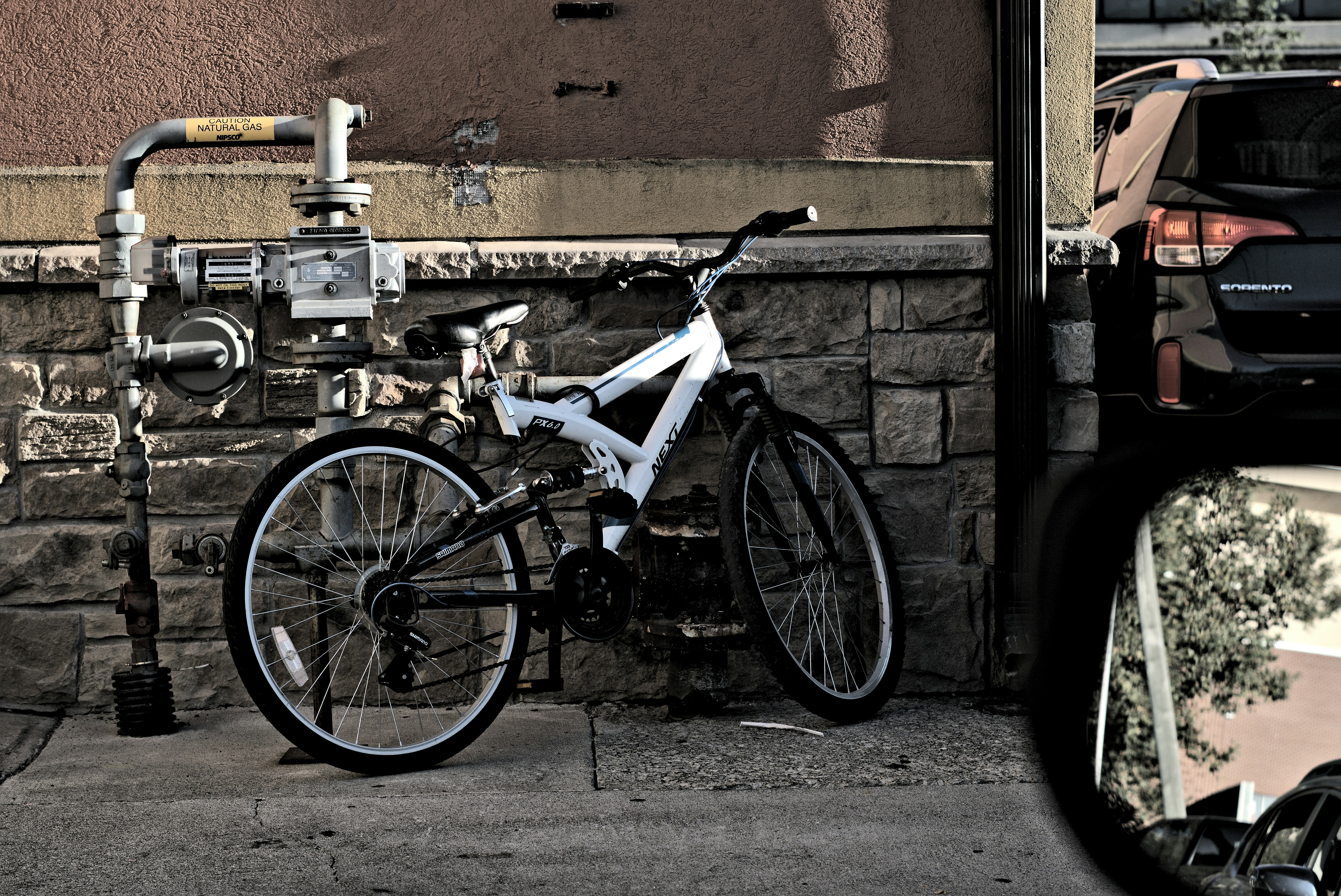a bicycle parked next to a brick wall