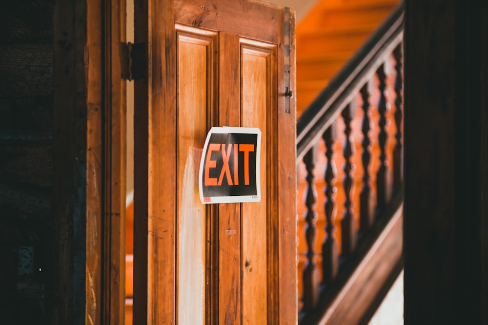 an exit sign is posted on a wooden door