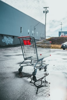 a shopping cart sitting in the middle of a parking lot