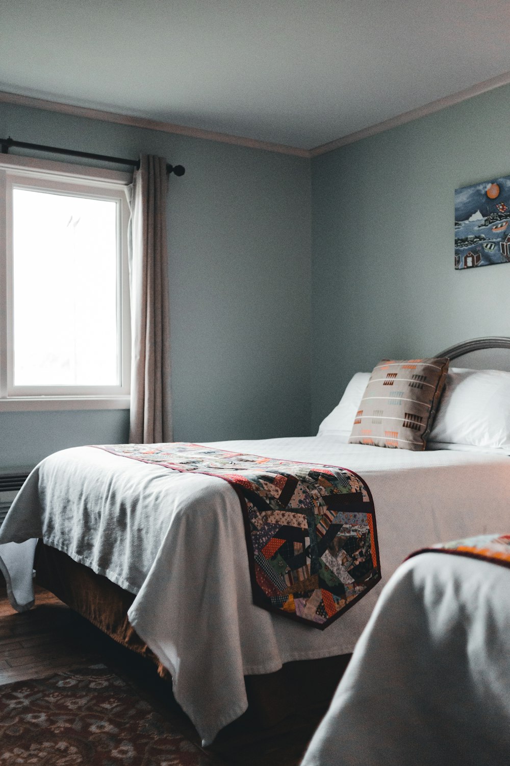una habitación con dos camas, una alfombra y una ventana