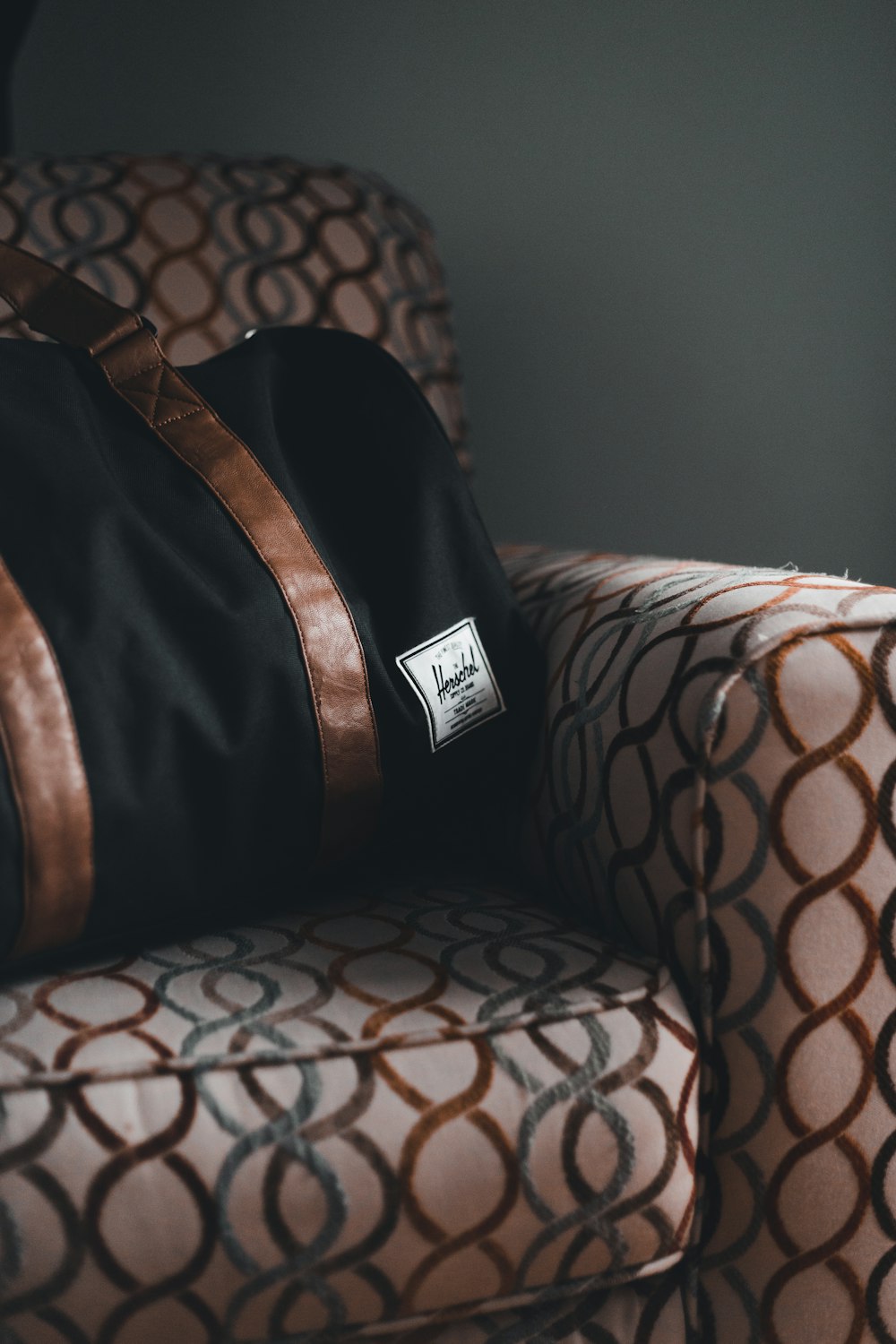 a brown and black bag sitting on top of a chair