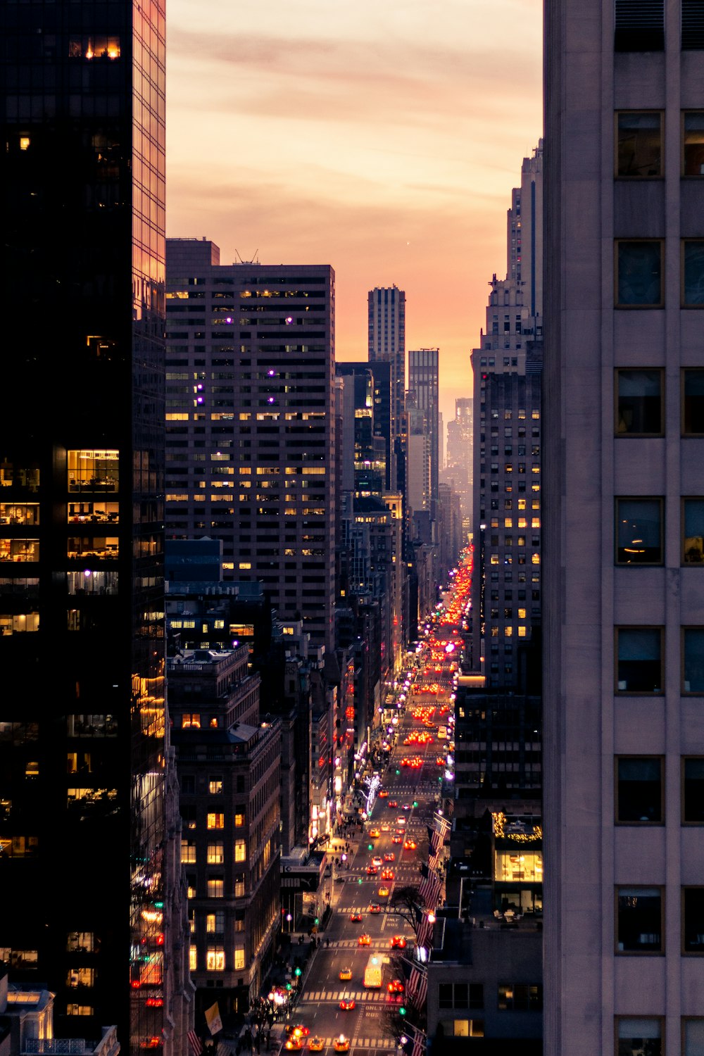 a city street filled with lots of traffic next to tall buildings